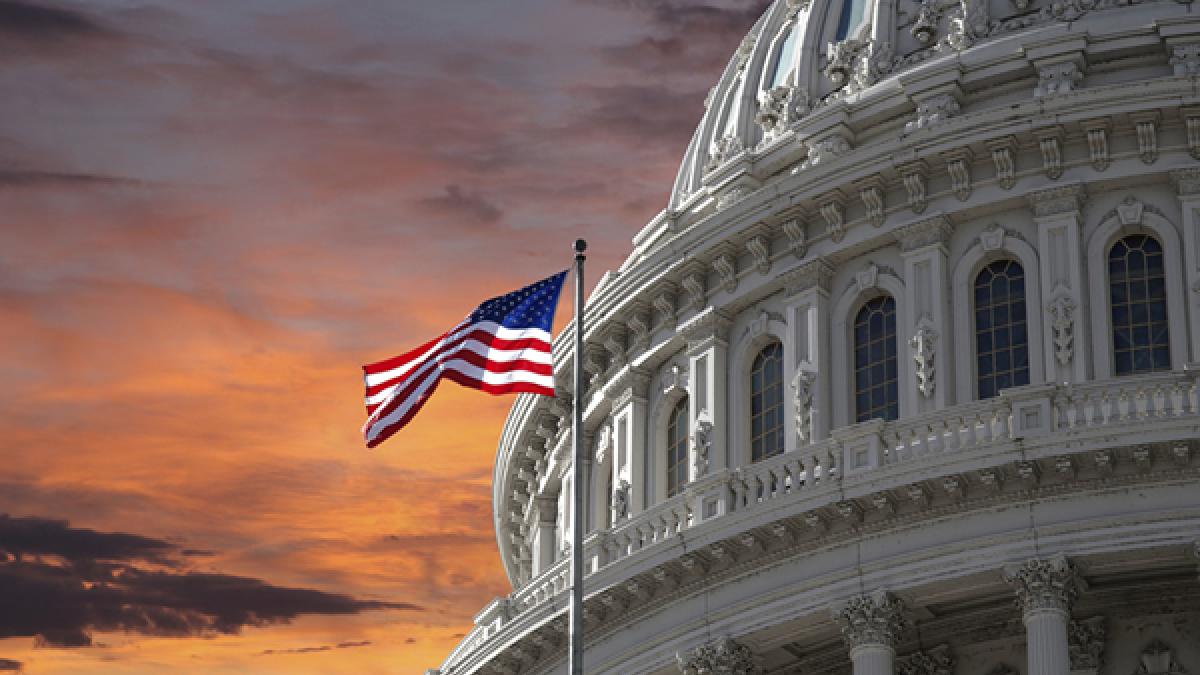 Capitol Dome and U.S. Flag against dramatic sky