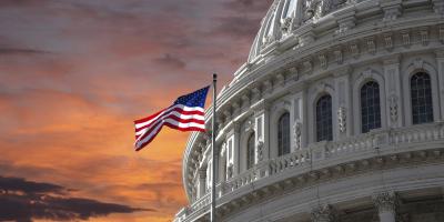 Capitol Dome and U.S. Flag against dramatic sky